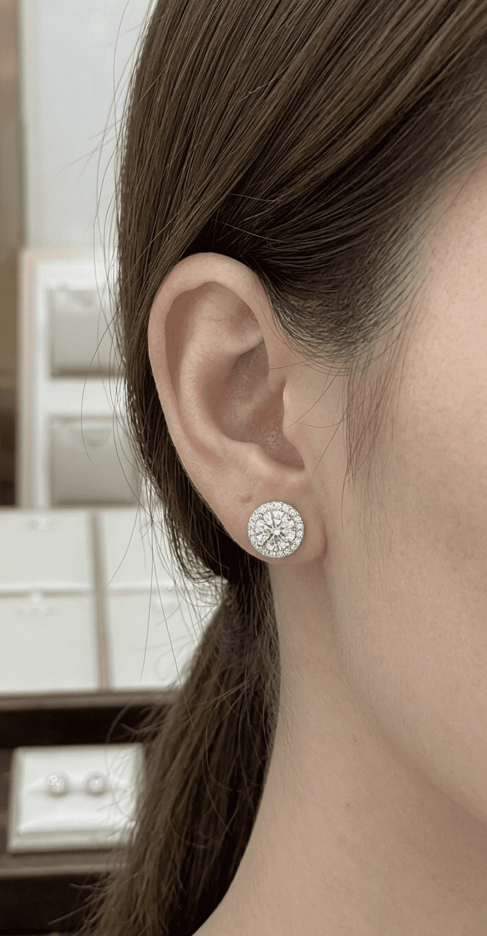 Halo moissanite stud earrings worn on model's ear, 2.6ctw sterling silver lifestyle shot.