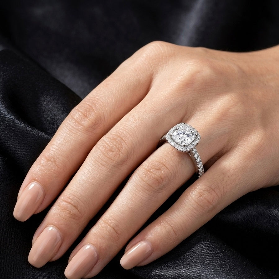 Hand wearing a diamond ring from jay & julie on a black satin background