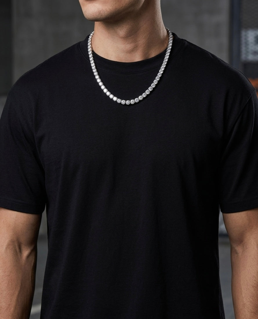 Person wearing a black t-shirt with a tennis silver moissnite nacklace