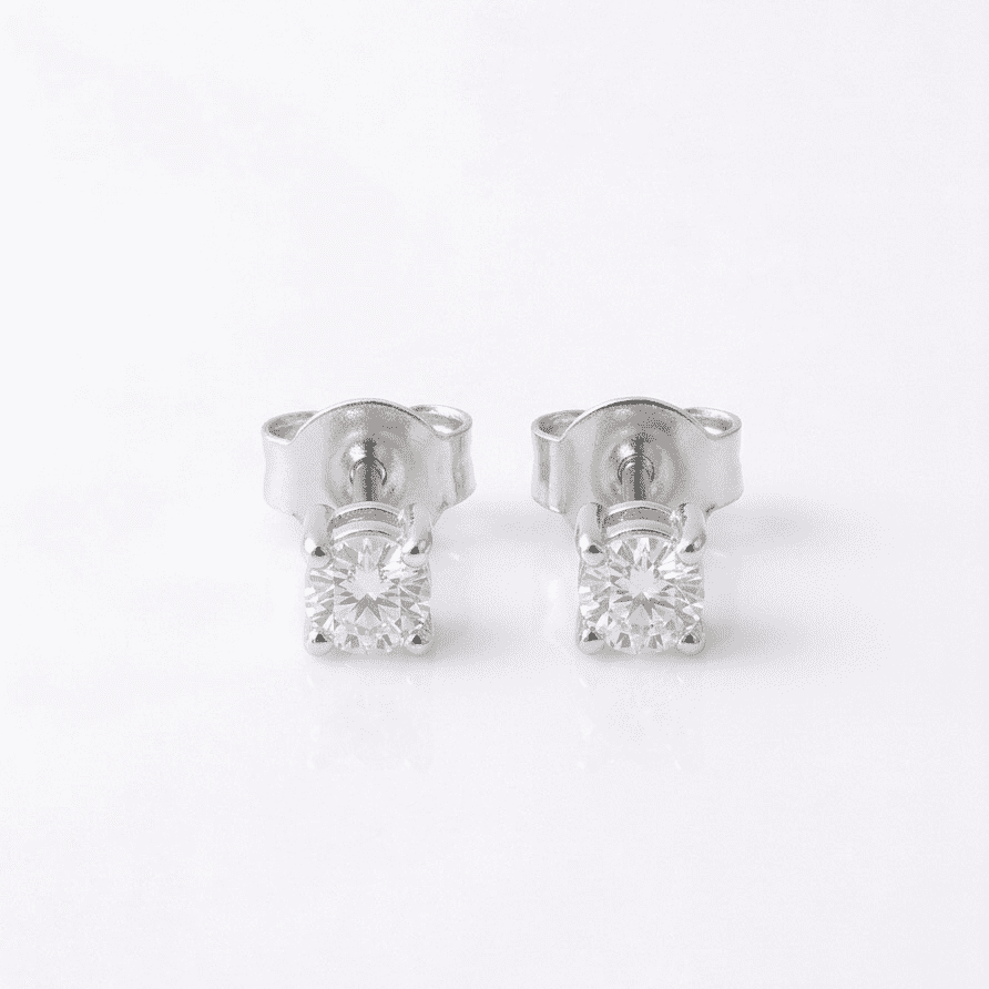 Pair of silver stud earrings with clear moissanite on a white background
