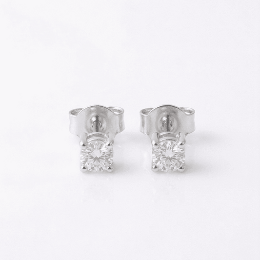 Pair of silver stud earrings with clear moissanite on a white background