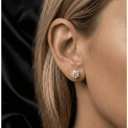 Close-up of an ear wearing a moissanite stud earring with a black background
