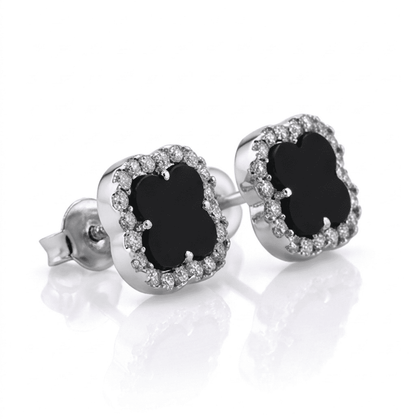 Pair of silver earrings with black gemstones on a white background