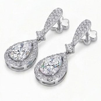 Pair of silver moissanite teardrop earrings with clear gemstones on a white background
