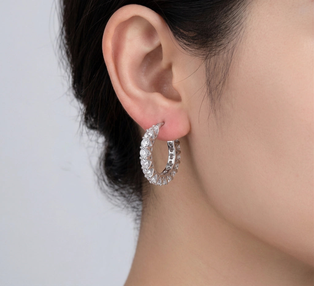 Stellara moissanite hoop earrings worn on model's ear, 3ctw fully hand set in 925 sterling silver lifestyle shot.