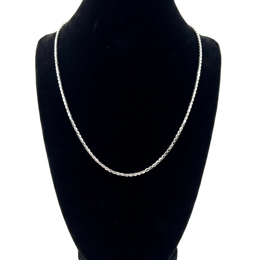 Silver chain necklace on a black mannequin bust against a white background