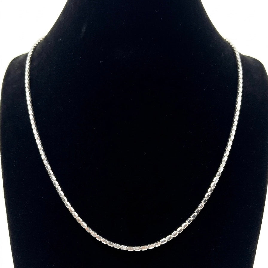 Silver necklace on a black velvet stand