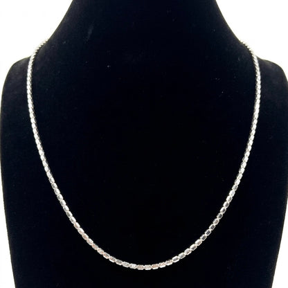 Silver necklace on a black velvet stand