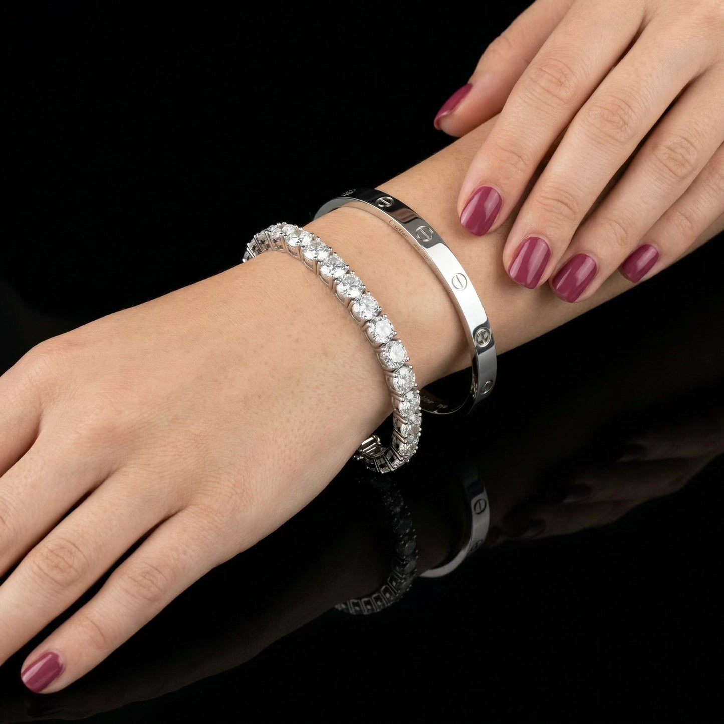 Moissanite tennis bracelet on women's wrist layered with Cartier Love bangle, 925 sterling silver.