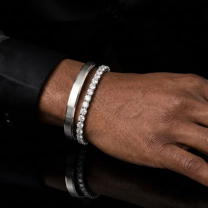 Moissanite tennis bracelet layered with Cartier Love bangle on male model's wrist, sterling silver.