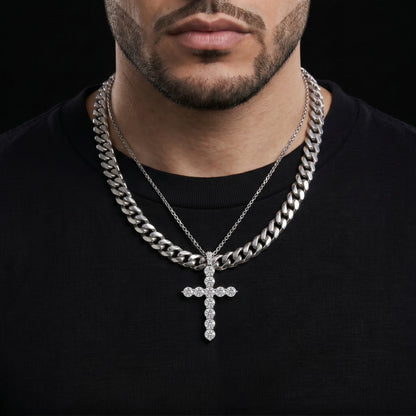 Man wearing a black shirt with two silver chain necklaces and a cross pendant.