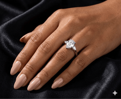 Aurora 2ct pear moissanite ring worn on finger, 2.2ctw in sterling silver band elegant lifestyle shot.