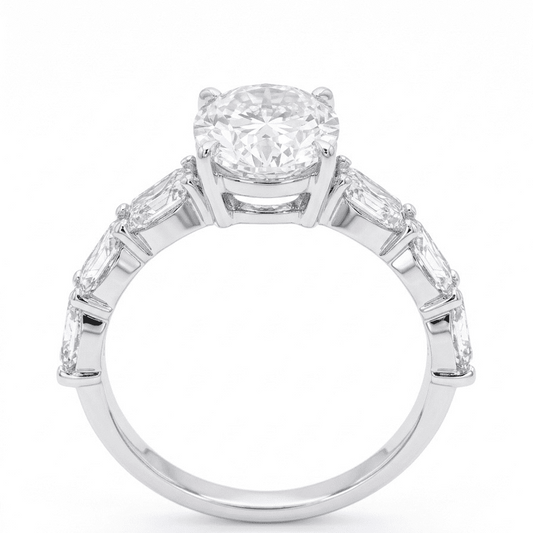 Moissanite ring with a oval central gemstone and smaller stones on a white background