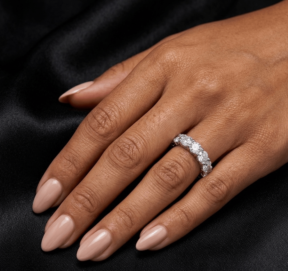 Hand wearing a diamond ring on a black background