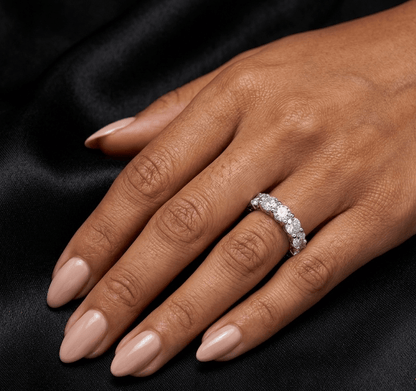 Hand wearing a diamond ring on a black background