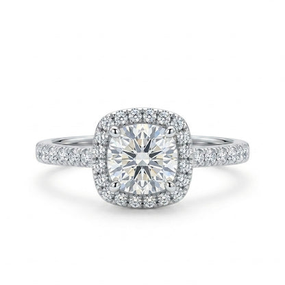 Diamond ring with a cushion-cut center stone and halo on a white background