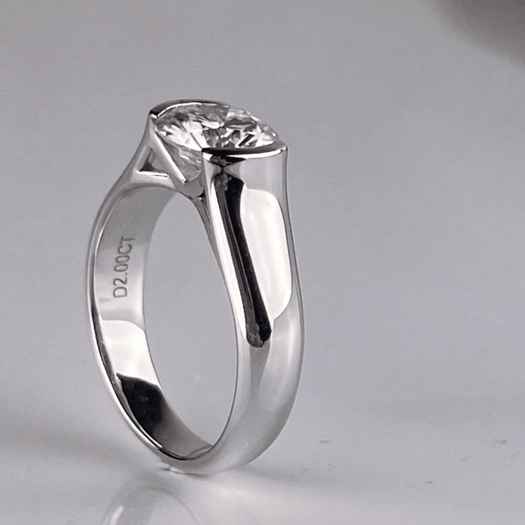 45-degree view of Whisperglow 2ct moissanite ring, brilliant cut stone in sterling silver stackable band.