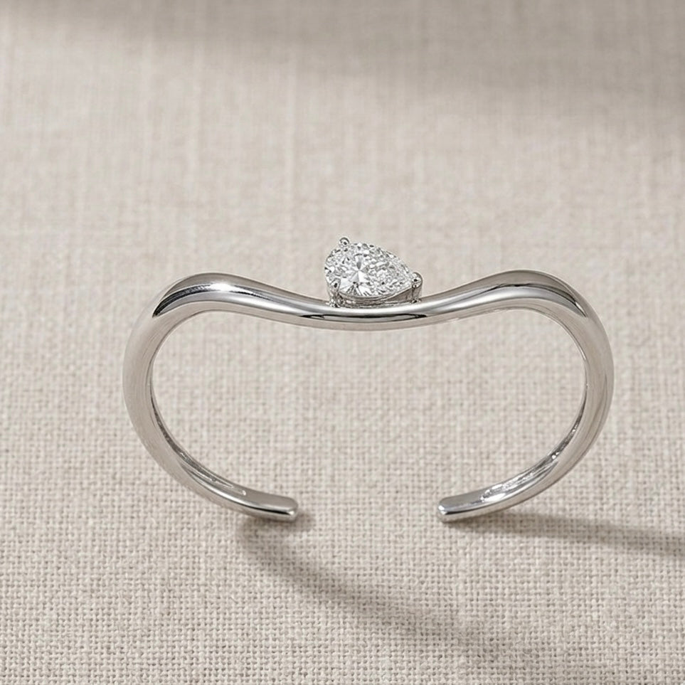 Top-down view of Helena moissanite bangle showing 2ct pear stone hand set layout in sterling silver.