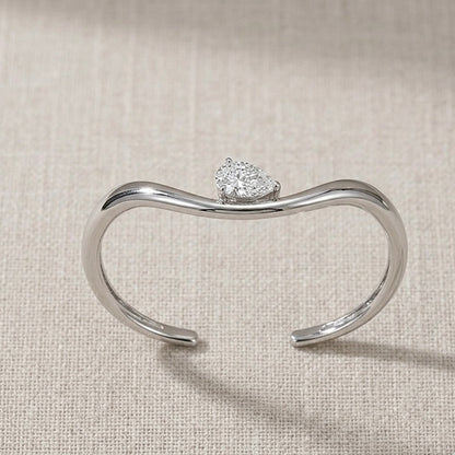 Top-down view of Helena moissanite bangle showing 2ct pear stone hand set layout in sterling silver.