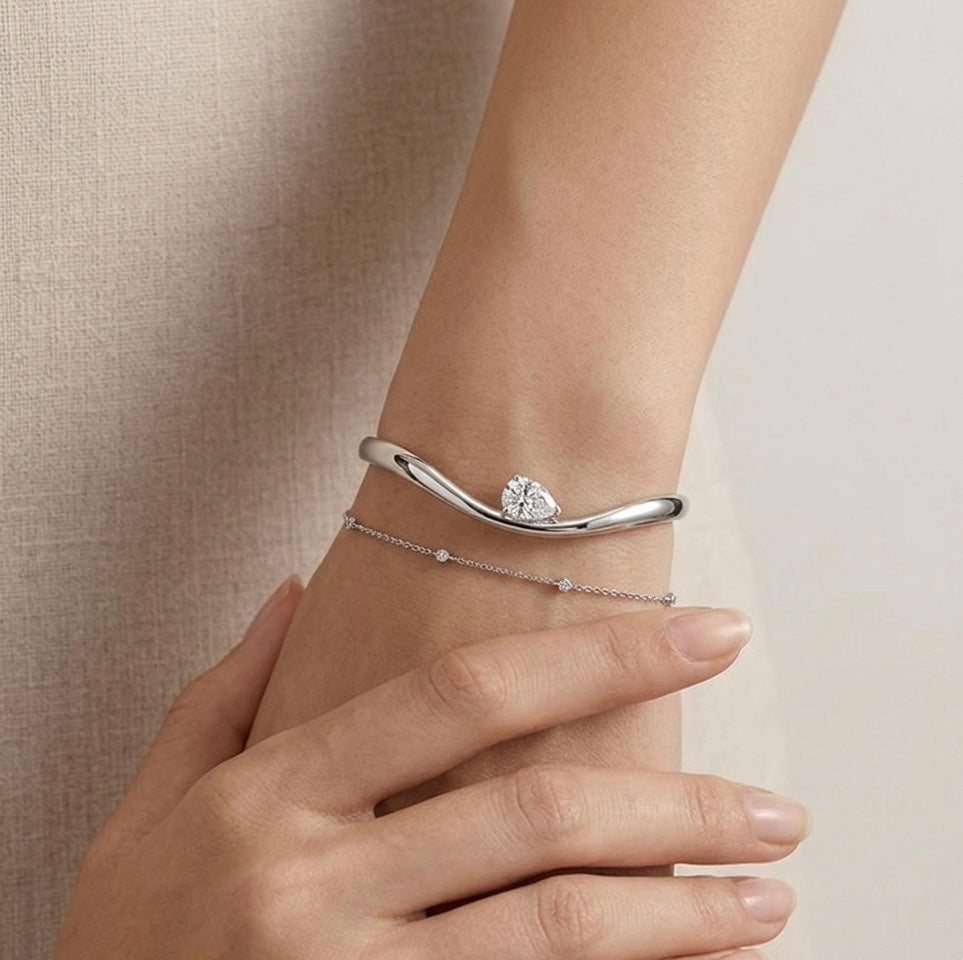 Helena moissanite bangle layered with bracelets, 2ct pear stone in 925 sterling silver stack styling.